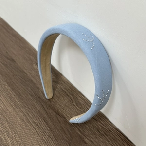 Detailed macro view of light blue denim fabric headband with sparkling rhinestone stars