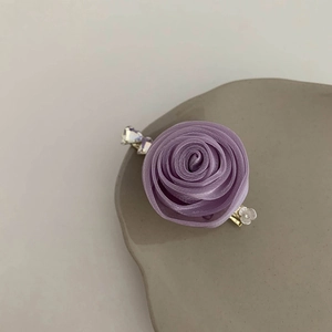 Détail d'une pince à cheveux rose violette faite main avec pétales en tissu et émail
