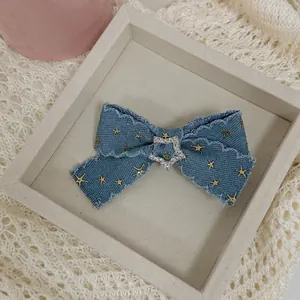 Vintage Y2K denim bow hair clip with gold star prints and sparkling rhinestone center