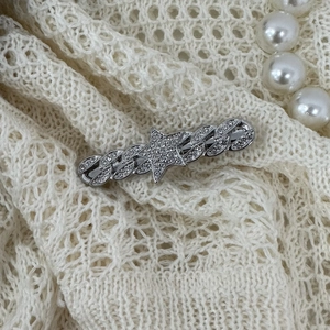 Silver Y2K star hair clip with sparkling crystals and Cuban chain design on lace background
