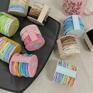 Lot d'élastiques à cheveux haute élasticité aux couleurs macaron sur une assiette