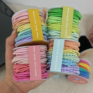 Gros plan d'un lot d'élastiques à cheveux colorés sur rouleaux aux tons macaron
