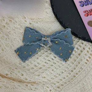 Detailed view of Y2K denim bow hair clip with gold stars and sparkling rhinestone heart