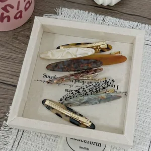 Barrettes à cheveux assorties en acétate léopard et marbre sur un plateau décoratif