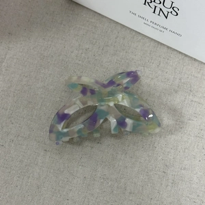 Dettaglio molletta a farfalla in acetato con texture marmorizzata e molla in metallo