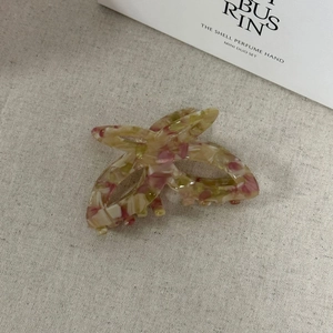 Dettaglio macro di un fermaglio per capelli a farfalla in acetato con trama marmorea