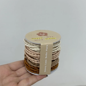 Détail d'élastiques à cheveux ondulés haute élasticité aux tons terre sur carton