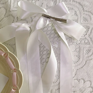 Détail de la pince à cheveux en ruban de satin blanc avec clip en métal argenté