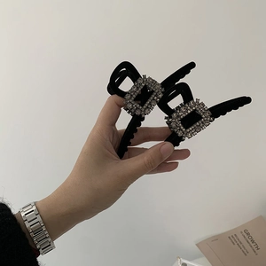 Elegant black velvet hair claw clips with square rhinestones shown in a model's hand