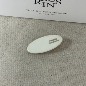 Détail de la barrette ovale en acétate blanc avec lettrage noir FRANCE Handmade