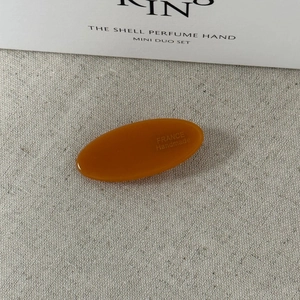 Détail de la barrette ovale en acétate ambré avec gravure dorée France Handmade gravée