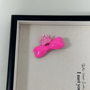 Nahaufnahme der pinkfarbenen Schleifen-Haarspange mit Perlenkrone in einer Box
