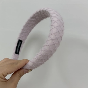 Detailed view of lavender diamond-quilted headband with handmade woven label