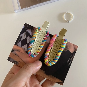 Dettaglio di fermagli per capelli in metallo rivestiti in lana intrecciata colorata