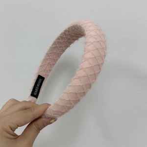 Detail of pink quilted knit headband with handmade label and diamond pattern texture