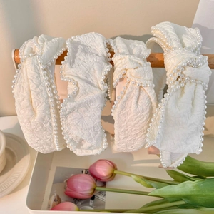 Elegant cream white fabric headbands with pearl trim and bow details in a set