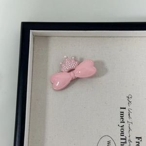 Detail der rosa Kronen-Bogen-Haarklammer mit Perlen auf einem Leinwand-Display-Tablett