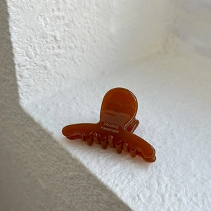 Detail showing the polished amber acetate hair claw with France Handmade gold label