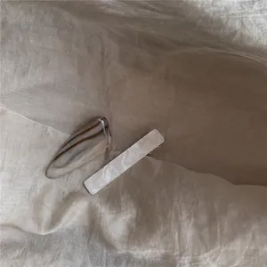 Gros plan de barrettes à cheveux effet marbre ambré sur un tissu en lin brun