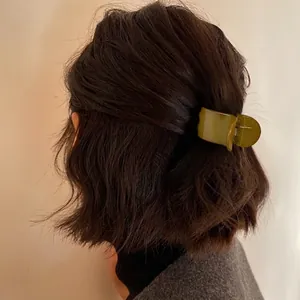 Olive green resin hair claw clip for high ponytail styling on brunette wavy hair