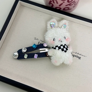 Close-up of plush white bunny hair clip with denim fabric and colorful rhinestones