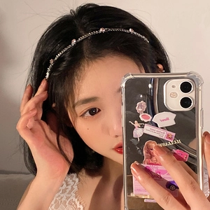 Close-up of a slim silver chain headband with pink rhinestones worn by a model