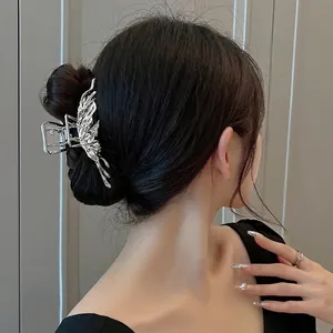 Silver liquid metal butterfly hair claw clip worn by a model in a high-contrast side view