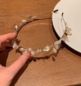 Detail of floral pearl headband with gold metal leaves and sparkling crystals