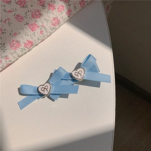 Gros plan de barrettes à nœuds bleu clair avec ornements centraux en forme de cœur