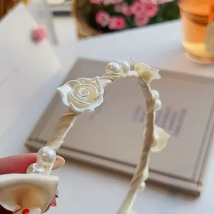 Detail eines Blumen-Haarreifens mit Seidenband, Harzrosen und glänzenden Perlen
