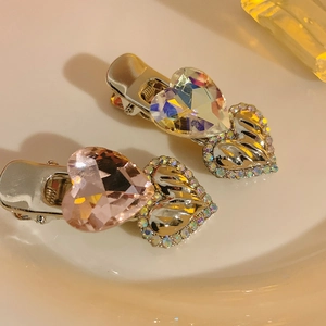 Close-up of Y2K heart hair clips featuring pink and iridescent crystals in gold settings