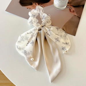 Detail of silk hair scrunchie with grey butterfly prints and hanging pearl charms