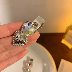 Detailed view of silver Y2K hair clip with dual hearts and iridescent crystal stones
