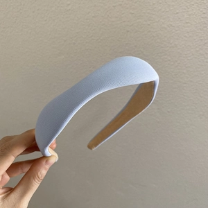 Detail of light blue padded headband showing thick knit fabric and anti-slip lining