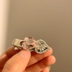 Detailed macro view of a Y2K sparkling rhinestone heart hair clip with pink crystal