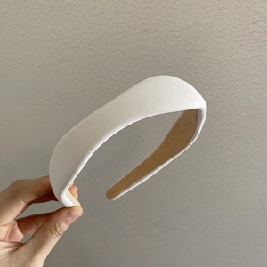 Close-up of a cream thick sponge headband featuring non-slip lining and soft fabric texture