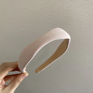 Close-up of pink padded sponge headband with soft knitted texture and thick rounded design