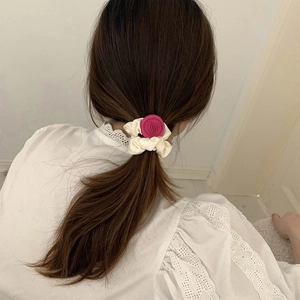 Close-up of white scrunchie with red heart wax seal charm on a brunette ponytail