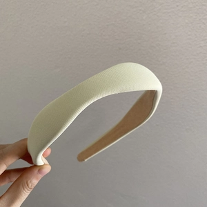 Detail showing knit texture and non-slip lining of the cream wavy headband