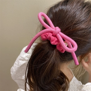 Chouchou à nœud rose pour femmes montrant une élégante coiffure en queue de cheval
