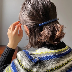 Detail of dark blue acrylic barrette hair clip worn on a stylish brunette bob hairstyle
