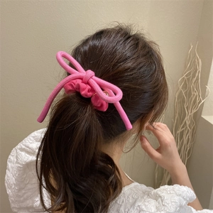 Chouchou rose en maille avec nœud pour femme attaché sur une queue de cheval élégante