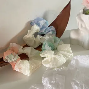 Drei Haargummis aus Organza mit Batik-Verlauf in einer Holzschale im süßen minimalistischen Stil