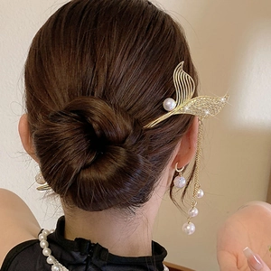 Detail van fishtail haarspeld met lange parelkwasten en kristallen inleg in een elegant kapsel