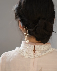 Elegant black hair stick with pearl tassels styled on a bun for a classic Chinese look