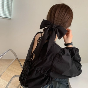 Détail d'une grande pince à cheveux nœud noir avec de longs rubans sur un mannequin