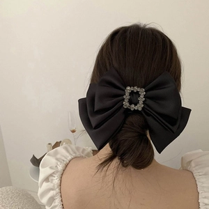 Close-up of black satin bow hair clip with square rhinestone buckle for women hair styling
