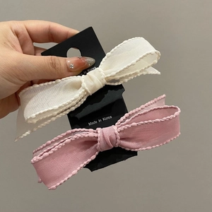 Detailed view of cream and pink ribbon bow hair clips with delicate lace edges