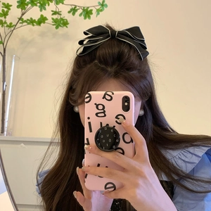 Elegante fiocco per capelli nero con bordi bianchi mostrato in un selfie allo specchio