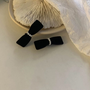 Close-up of a vintage black velvet bow hair clip featuring elegant faux pearl center